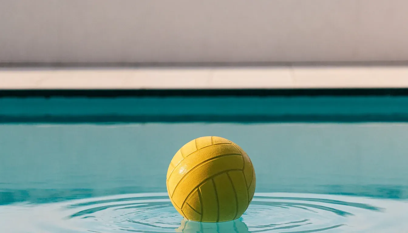 Ein gelber Ball treibt auf ruhigem türkisfarbenem Beckenwasser, feine Wellen im weichen Licht.